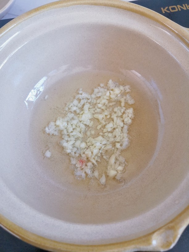 番茄水豆腐,起锅,倒入适量油,烧热,下蒜末炒香。
