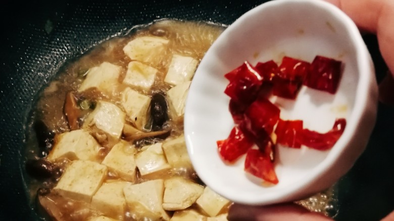 蘑菇炖豆腐,汤汁不用完全收干,留下一些拌饭吃,放入<a style='color:red;display:inline-block;' href='/shicai/ 6195'>油辣椒</a>,关火出锅。