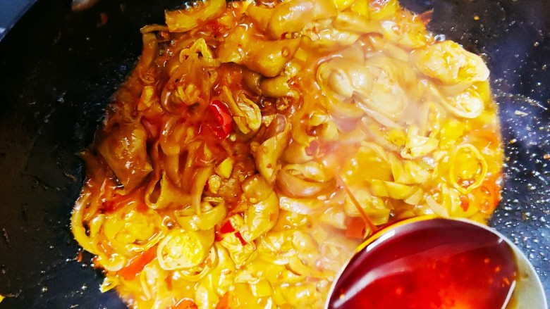 爆炒肥肠,少量水后加入一勺自制红油提色,再加入剩下的一半洋葱,翻炒