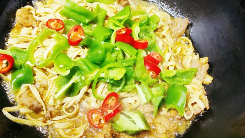 青椒炒千张,倒入青椒,翻炒