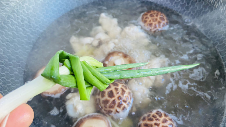 鸡腿炖蘑菇,放入葱结大火煮沸转中火煮20分钟