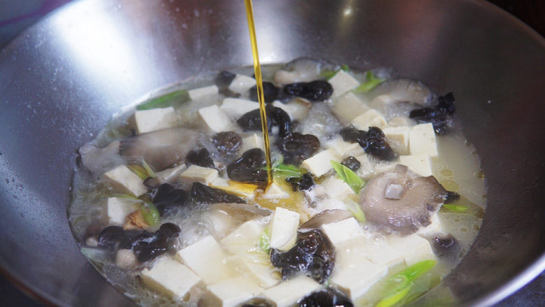 蘑菇炖豆腐,淋入<a style='color:red;display:inline-block;' href='/shicai/ 3738'>芝麻油</a>,撒香葱末,关火,出锅