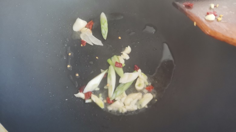豆芽炒粉丝,待猪油融化,下入葱蒜和干辣椒炒香