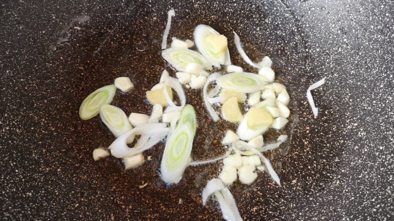 酸辣娃娃菜,炒锅内倒适量的食用油烧热,下入葱姜蒜炒出香味。