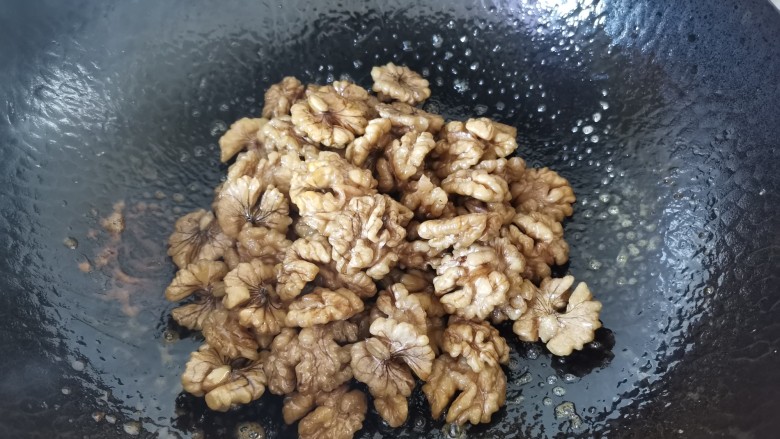 琥珀核桃,烧至汤汁粘稠搅匀,使核桃都裹上糖份,捞出沥干