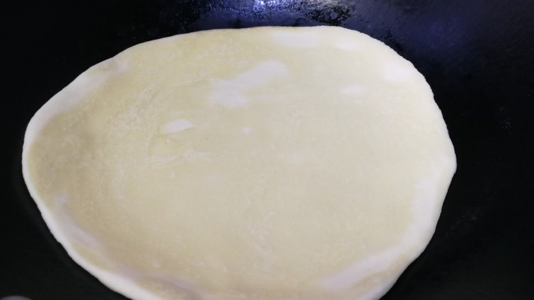 家常烫面饼,热锅不放油,锅热放入饼胚,中小火烙15秒翻面,再烙15秒。