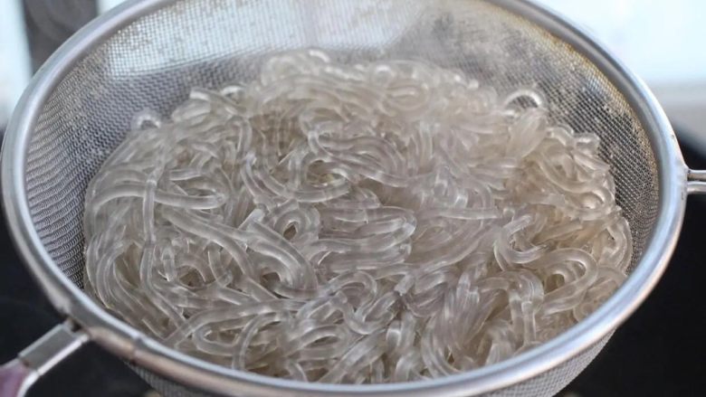 豆芽炒粉丝,再将红薯粉丝放进去煮熟,捞出浸泡在温水中防止粘连。