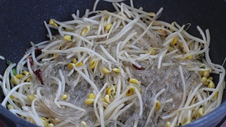 豆芽炒粉丝,然后将红薯粉条捞出来放进锅中,混合拌炒均匀。