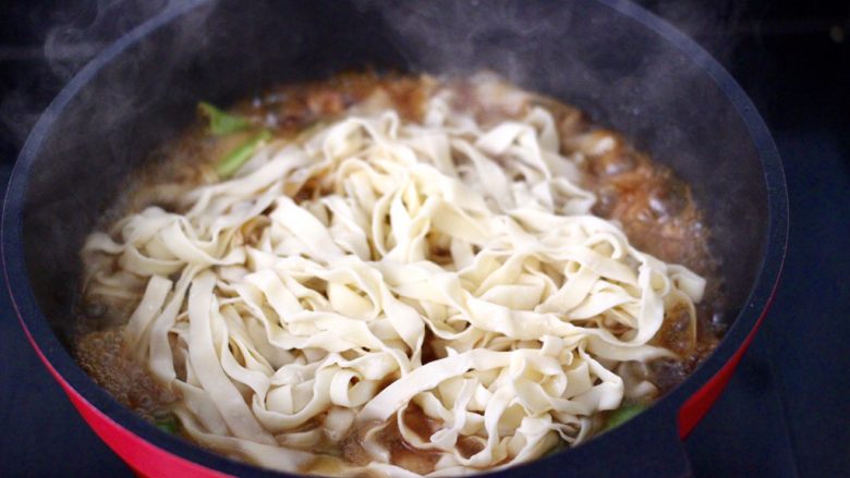 鸡腿肉豆角焖面,上面铺上新鲜面条，盖上锅盖中火焖煮至。