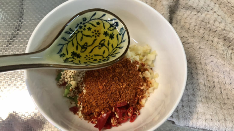 酸辣娃娃菜,油烧到八成热，等十来秒稍微降温，把热油分次浇在调味料上