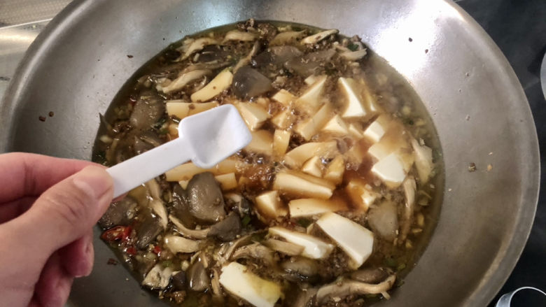 蘑菇炖豆腐,开盖尝下咸淡,根据个人口味补充少许盐