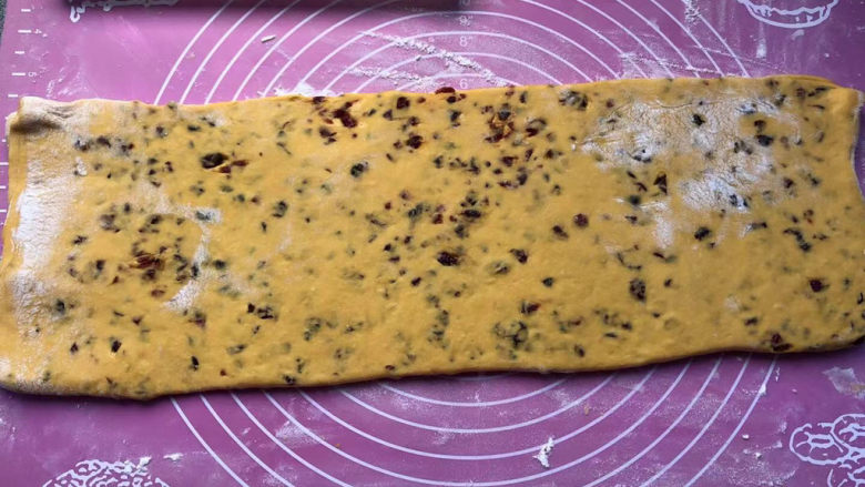 千层南瓜糕,把面皮横过来,继续擀成长条。