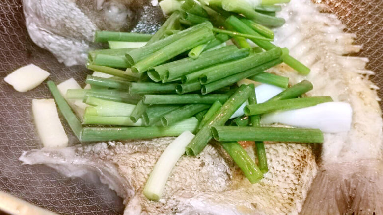 橘子皮烧鱼,葱姜加入鱼头,鱼骨中
