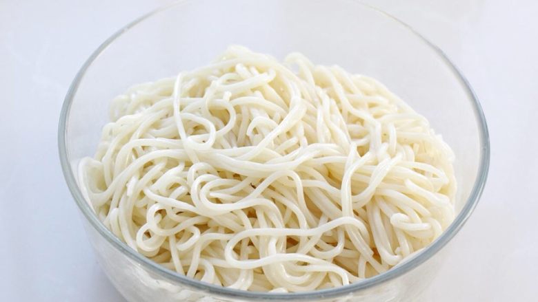 青椒肉丝面,沥干水分放入碗中,淋入一汤匙食用油拌匀,以免面条粘连到一起。