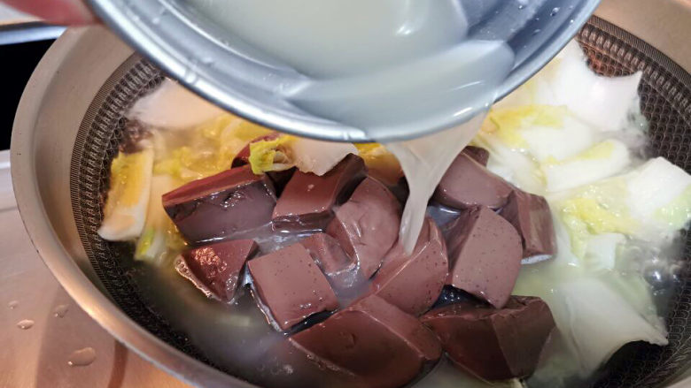 金汤肥牛,白菜捞熟放入锅中,加入鸭血,海鲜菇与高汤烧开