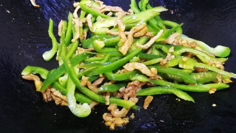 青椒肉丝面,放青椒丝,文火翻炒均匀,炒出青椒香味。