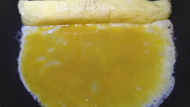 秋葵厚蛋烧,再倒入四分之一蛋液,中小火摊平。