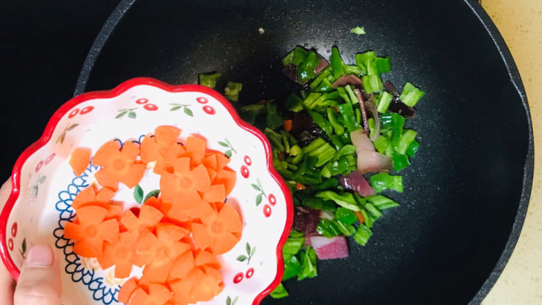 尖椒炒腊肉,加入胡萝卜花,煸炒均匀