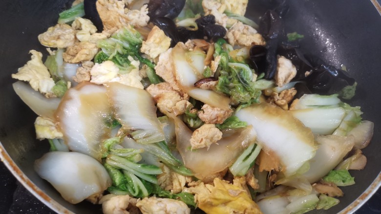 白菜炒木耳,白菜叶子也软了后,放入调好的料汁,加盐