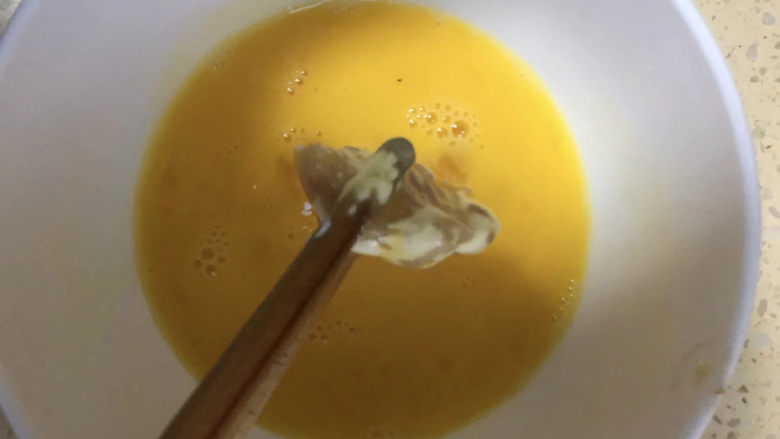 老北京鸡肉卷,碗中打一个鸡蛋,搅拌均匀。用筷子夹鸡肉沾满蛋液,或者直接把蛋液倒入鸡肉块中,这样简单粗暴也不错,不用那么细致啦。