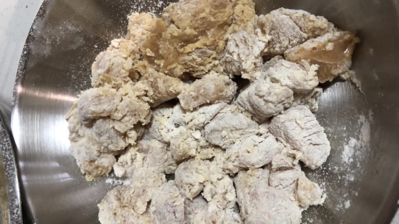 老北京鸡肉卷,都裹满面粉后,感觉面粉不够厚,在鸡块上撒点水,继续将两个盆扣起来摇晃。