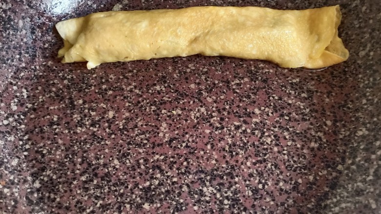 秋葵厚蛋烧,从底下小心翼翼的往上卷,尽量卷紧一点,最后成品会好看一些。卷到头