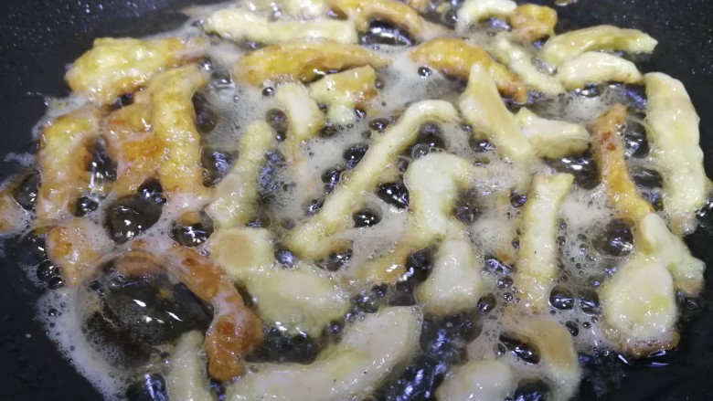 老北京鸡肉卷,平底锅,倒入比炒菜多点的油,油5成热逐条下鸡肉条,文火慢煎。