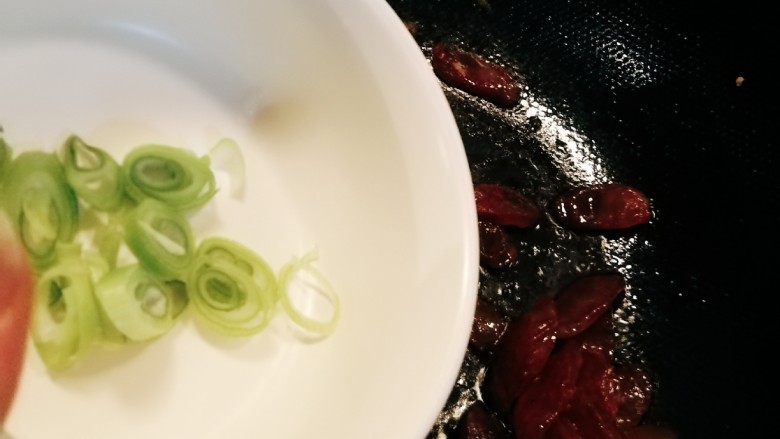 尖椒炒腊肉,放入葱片增香,翻炒均匀。
