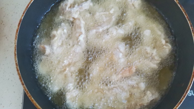 老北京鸡肉卷,锅中烧油,油温6成热,下入鸡肉条中火炸