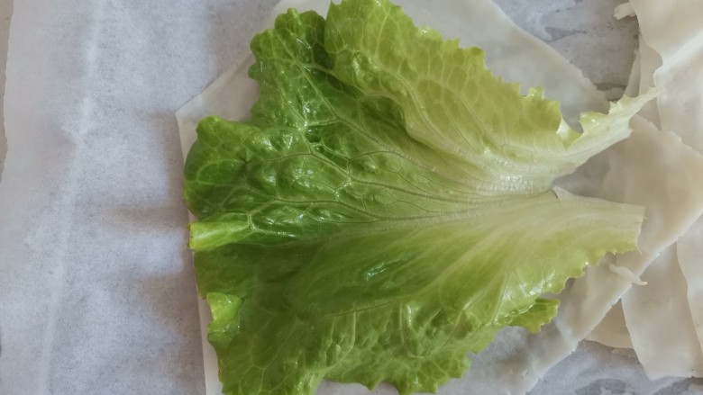 老北京鸡肉卷,开始卷饼,饼皮上放一片生菜