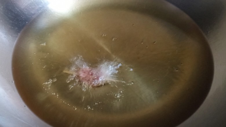 牙签羊肉,热锅烧油,油尽量多一些,油少空间小,更容易粘锅底。大概烧到五六成热的时候,放一串进去,周围都冒小泡泡就可以了