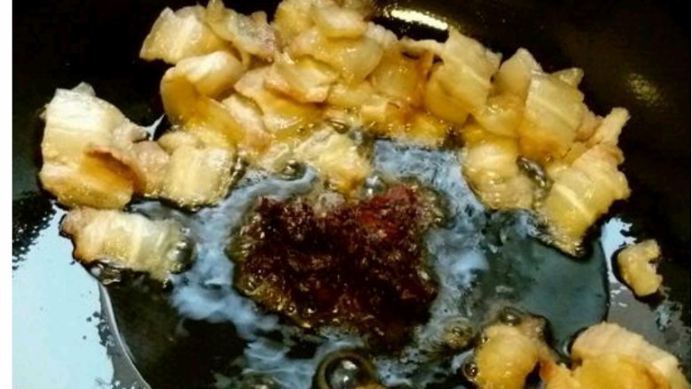 回锅肉,8 把肉片赶到边上，下郫县豆瓣炒香。
