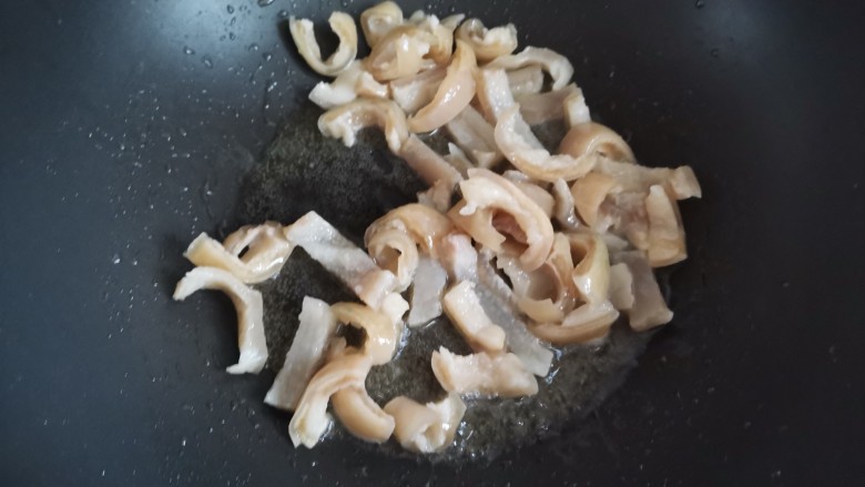 黄豆炖猪皮,起锅烧油,下入猪皮翻炒