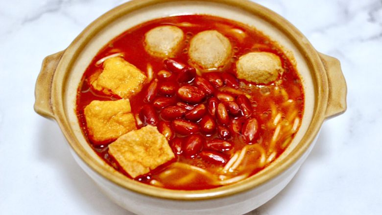 酸辣米线,上面依次铺上煮好的丸子和油豆腐,炸好的花生米,倒入煮好的酸汤鱼汤汁。