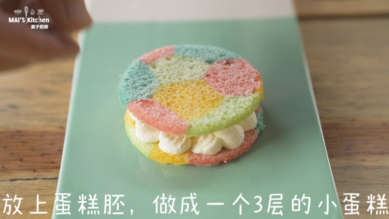 彩虹小蛋糕 ,取一片圆形的蛋糕胚挤上打发好的奶油,放上蛋糕胚,做成一个3层的小蛋糕。