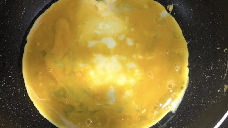 小葱炒鸡蛋,锅中加入适量油,油烧热以后,倒入鸡蛋液。