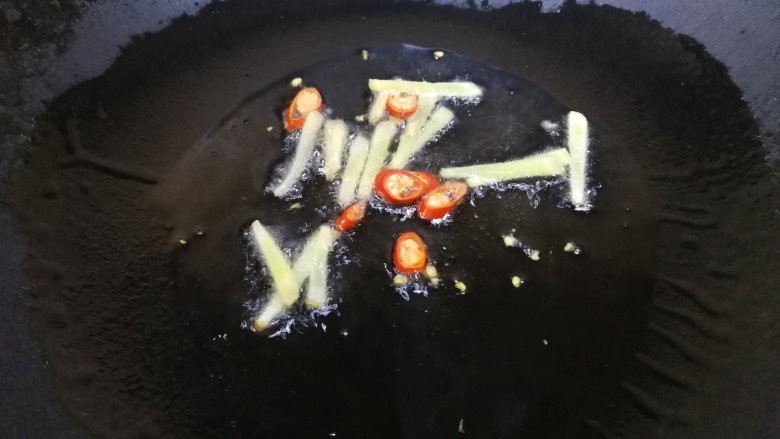 油豆腐烧肉,热锅凉油,放入姜丝和一半的小米辣文火炒香。