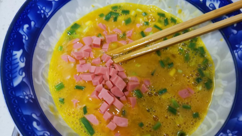 芹菜叶炒鸡蛋,加入火腿丁,搅拌均匀