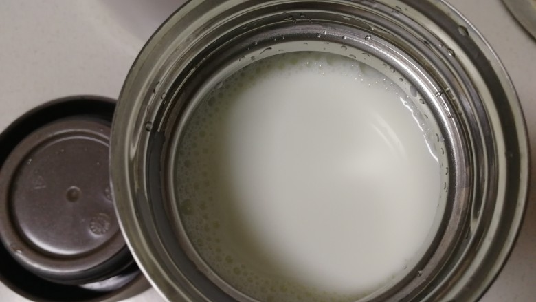 手工酸奶,牛奶倒入焖烧杯,用勺子舀些牛奶,滴在手背上,试试温度,感觉温热不烫就可以。
