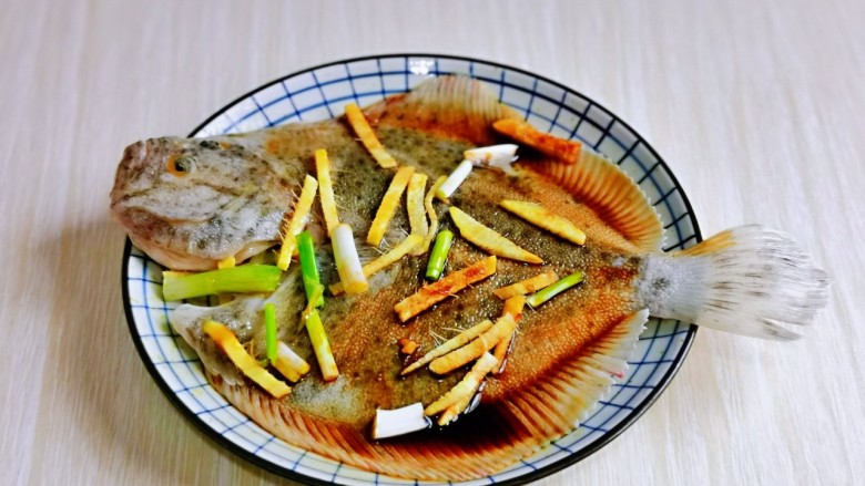 红烧多宝鱼,再摆放上葱姜,腌制20分钟。