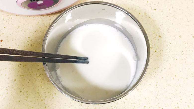 手工酸奶,用筷子不停地搅拌,使鲜牛奶与发酵乳充分融合起来