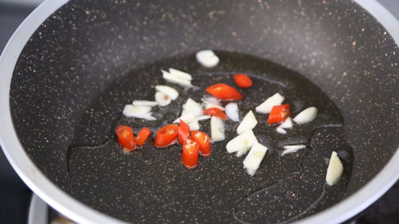 红烧油豆腐,锅里烧热油,爆香蒜和小米辣
