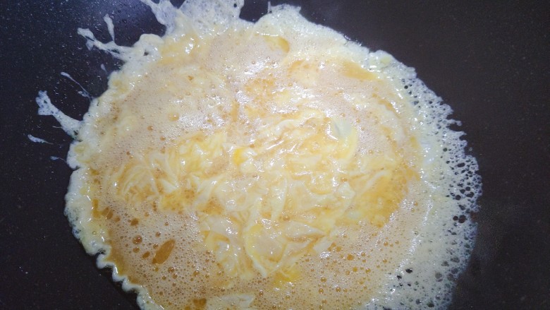 小葱炒鸡蛋,待鸡蛋液稍稍凝固