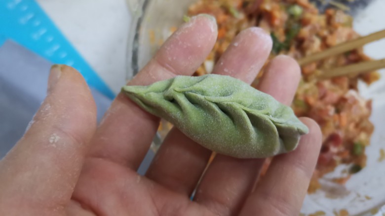 芹菜猪肉柳叶水饺,起头往里捏,然后左边捏一下,右边捏一下,直到收口捏紧,捏成柳叶饺