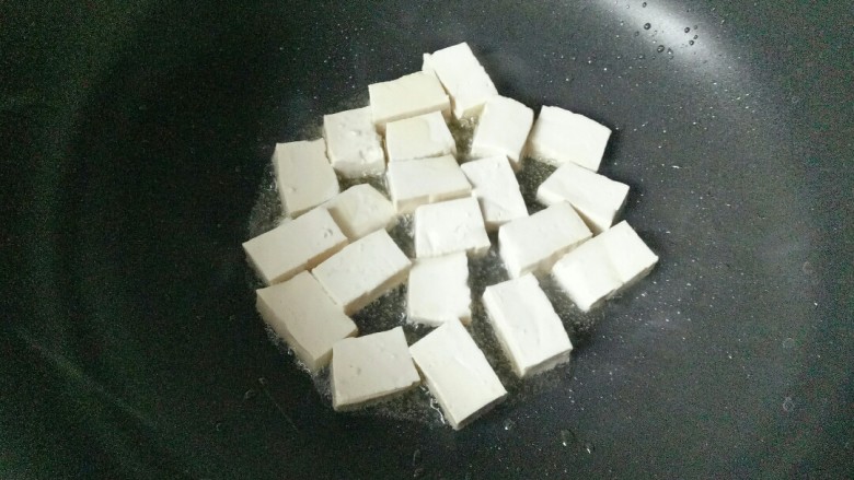 雪菜豆腐,炒锅中加入适量花生油烧热,放入豆腐块