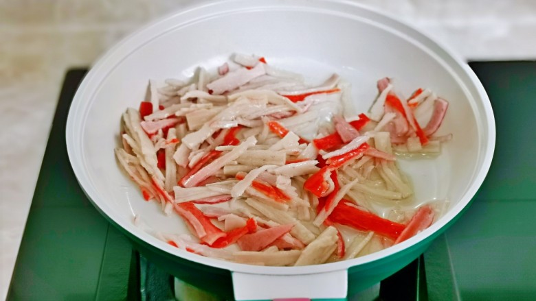 小葱炒鸡蛋,起油锅,加入蟹柳丝翻炒。