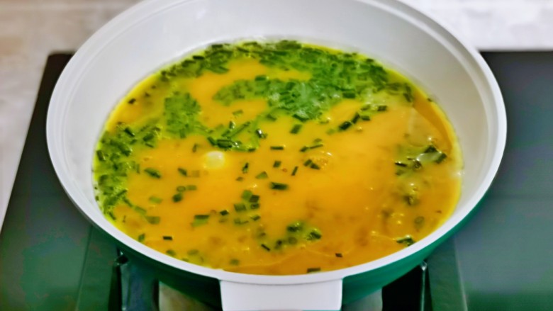 小葱炒鸡蛋,起油锅倒入蛋液小火煎,不断用筷子搅拌。