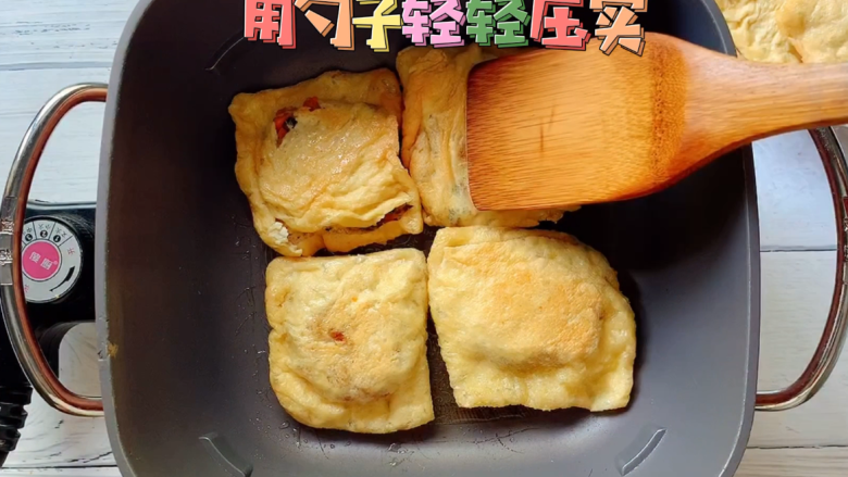 油豆腐烧肉,两面中小火慢煎，并用木勺子轻轻压实。