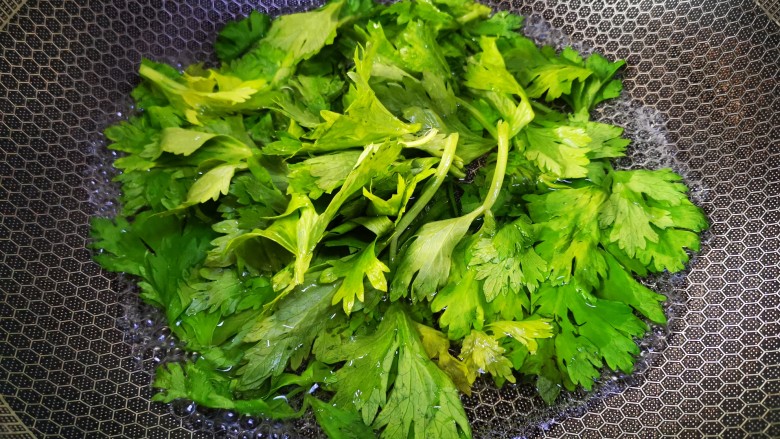 芹菜叶炒鸡蛋,锅中加适量清水煮开,加一点盐,将芹菜叶焯水