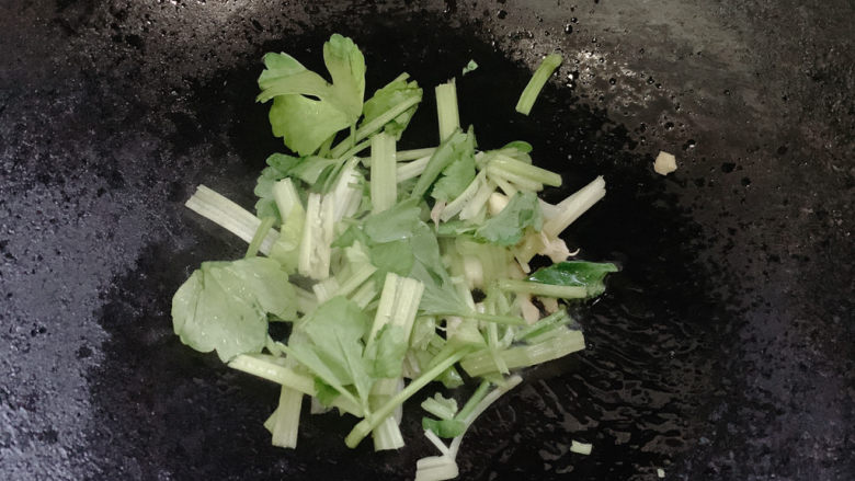 芹菜目鱼花,将芹菜切段,加入翻炒。